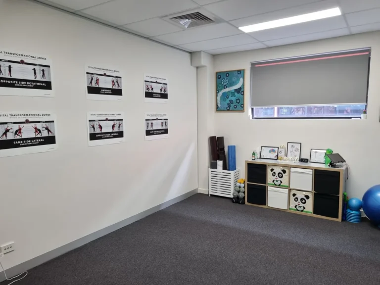 Physical therapy room with exercise posters and equipment.