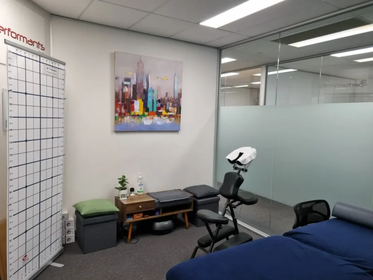 Therapy room with artwork, massage chair, and examination chart.